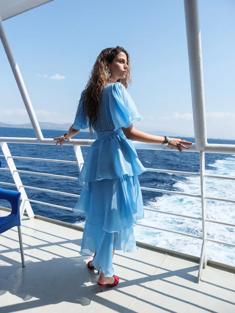 Πίσω και πλάγια όψη του φορέματος Nazezhda Sarah Dress Baby Blue που προβάλλει την αέρινη κίνηση του υφάσματος και την εντυπωσιακή πλάτη.