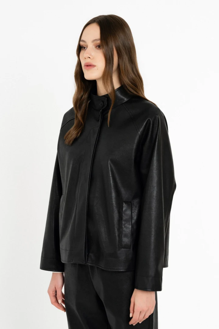 Κοντινό πλάνο στο μαύρο jacket Philosophy, εστιάζοντας στον κομψό όρθιο λαιμό, το μπροστινό κούμπωμα και την πρακτική πλαϊνή τσέπη.