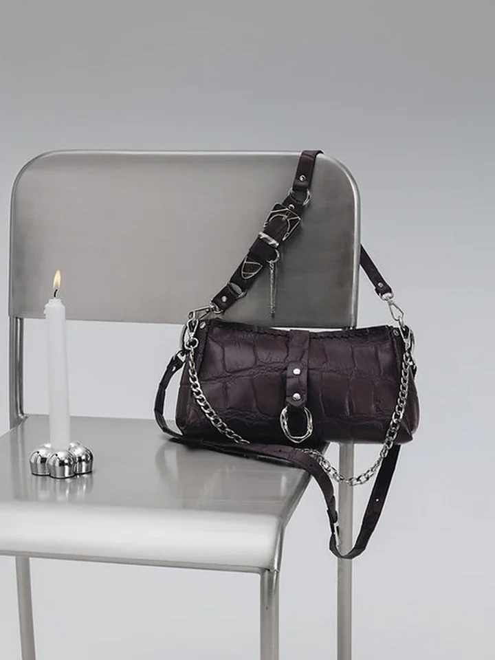 Studio φωτογραφία της τσάντας Individual Art Leather Mexican Moon Dark Plum Croc δίπλα σε διακοσμητικό κερί