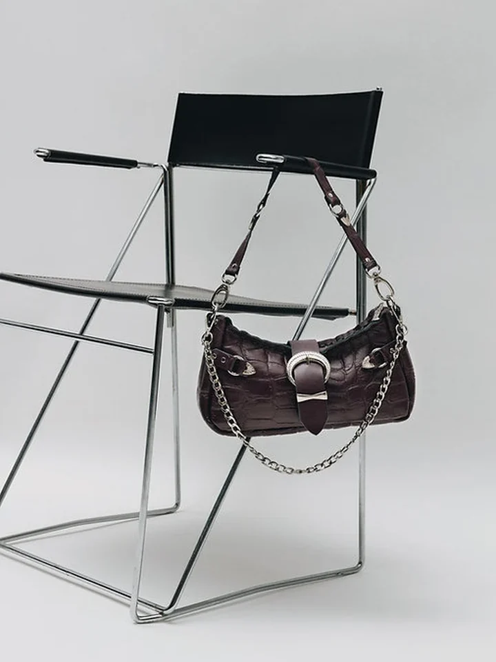 Χειροποίητη δερμάτινη τσάντα Individual Art Leather Kiss of Life Dark Plum Croc κρεμασμένη σε μεταλλική καρέκλα