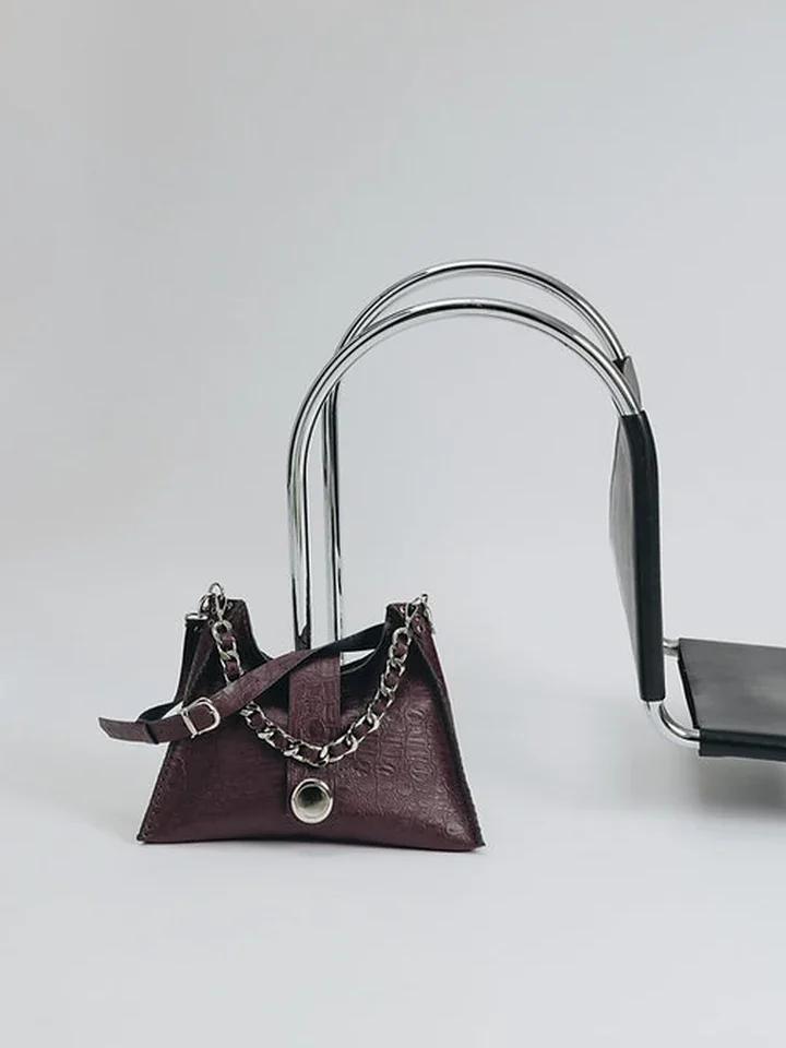 Μεγάλη χειροποίητη δερμάτινη τσάντα Individual Art Leather To the wilder Dark Plum Croc δίπλα σε μεταλλική καρέκλα design