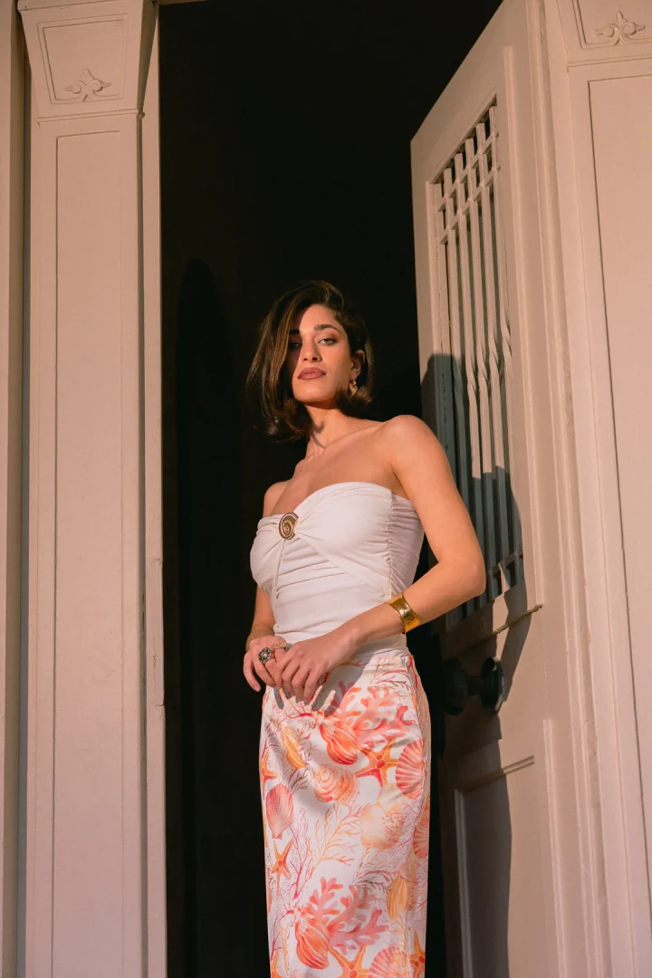 γυναίκα που φοράει το κομψό λευκό τοπ five pm coral white strapless top με χρυσό διακοσμητικό κοχύλι στο μπούστο