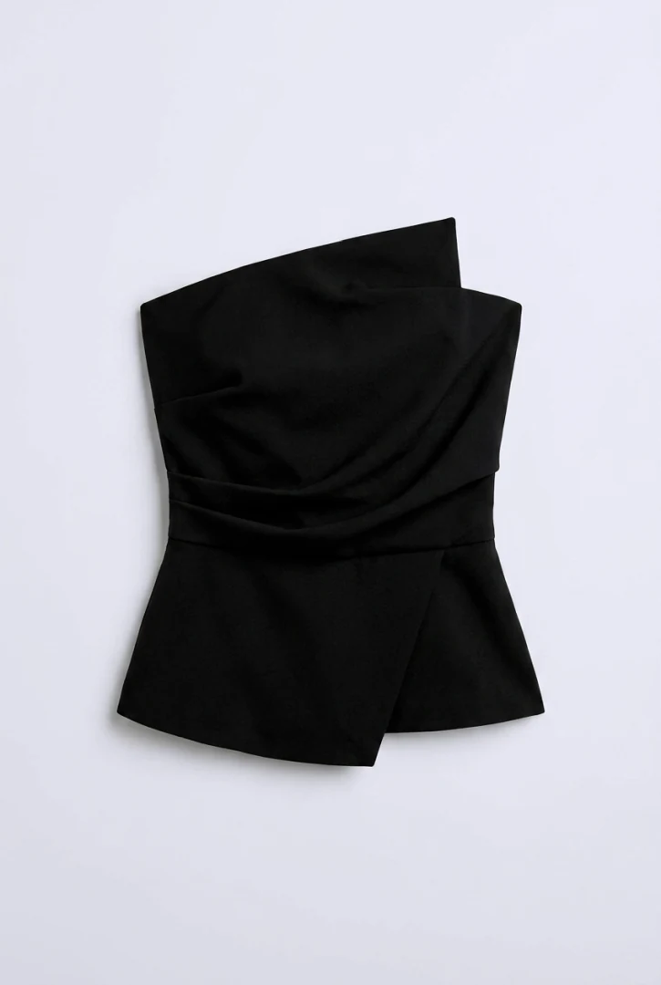 Επίπεδη λήψη (flatlay) του μαύρου στράπλες τοπ Mallory The Label Astra Black Bustier που προβάλλει τον ασύμμετρο ντραπέ σχεδιασμό του.