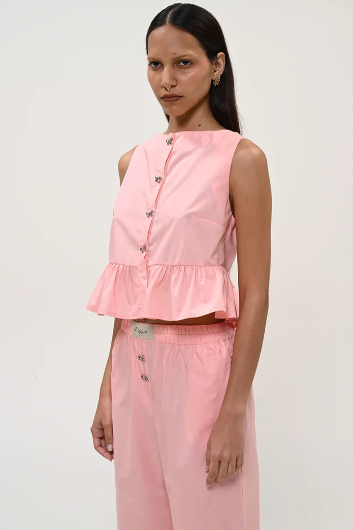 κοντινό πλάνο στο απαλό ροζ cropped top boom pink top που αναδεικνύει τα διακοσμητικά κουμπιά και την κλειστή λαιμόκοψη