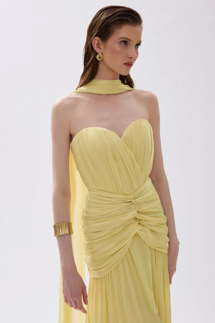 κοντινό πλάνο στο strapless μπούστο και τις κομψές σούρες στο φόρεμα daphne cecelia butter yellow με την ασορτί εσάρπα