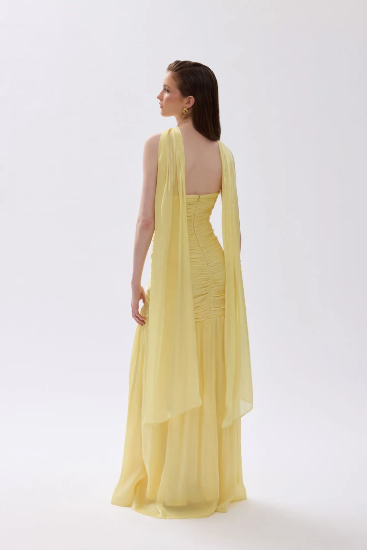πίσω όψη με το αιθέριο βραδινό φόρεμα daphne cecelia butter yellow και την αέρινη λεπτομέρεια λαιμού που πέφτει στην πλάτη