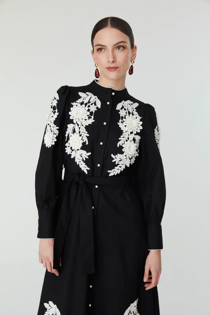 Κοντινότερη λήψη του φορέματος Jovonna London Jemima Dress, προβάλλοντας την κομψή εφαρμογή στο μπούστο, τα ανάγλυφα κεντήματα και το κλείσιμο με κουμπιά.