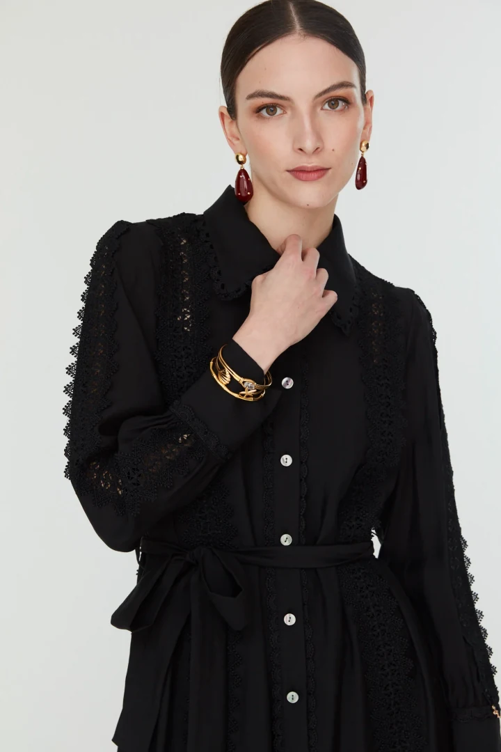 Κοντινό πλάνο στο φόρεμα Jovonna London Corina Dress, εστιάζοντας στον κλασικό γιακά, το μπροστινό κούμπωμα και την περίτεχνη δαντέλα στα μανίκια.