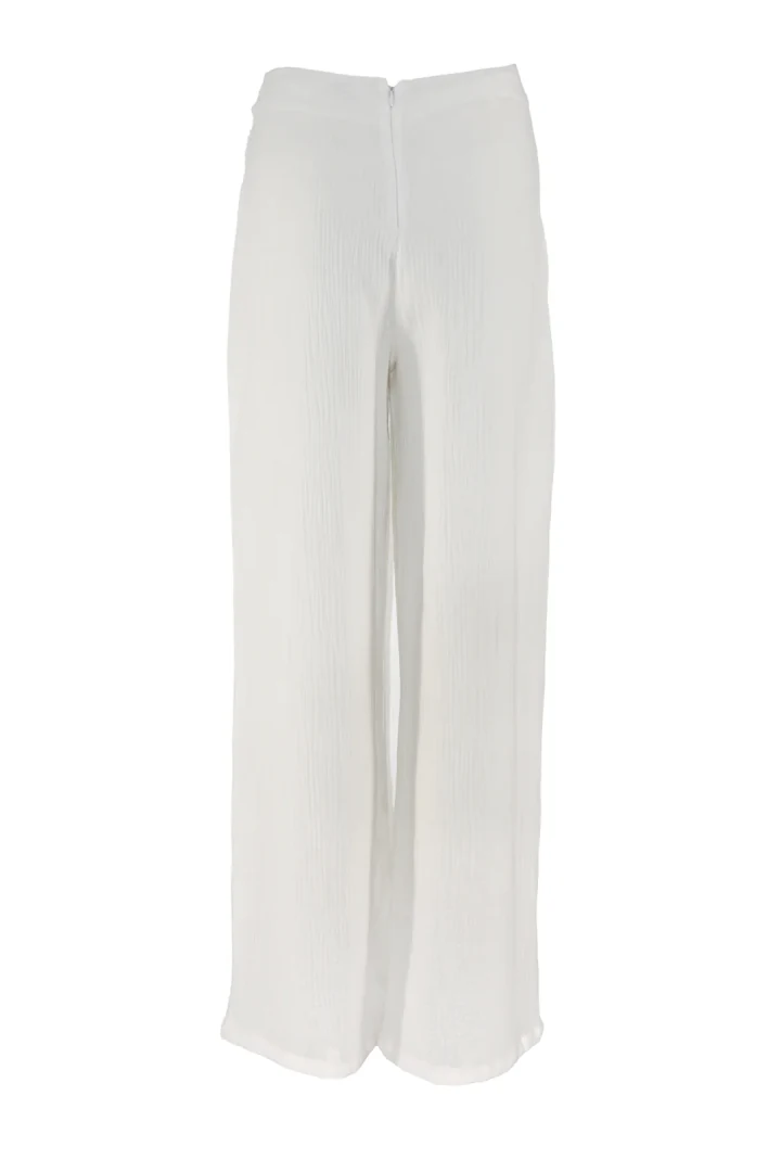πίσω όψη με το αέρινο λευκό wide-leg παντελόνι five pm coral white trousers που αναδεικνύει την κομψή του γραμμή