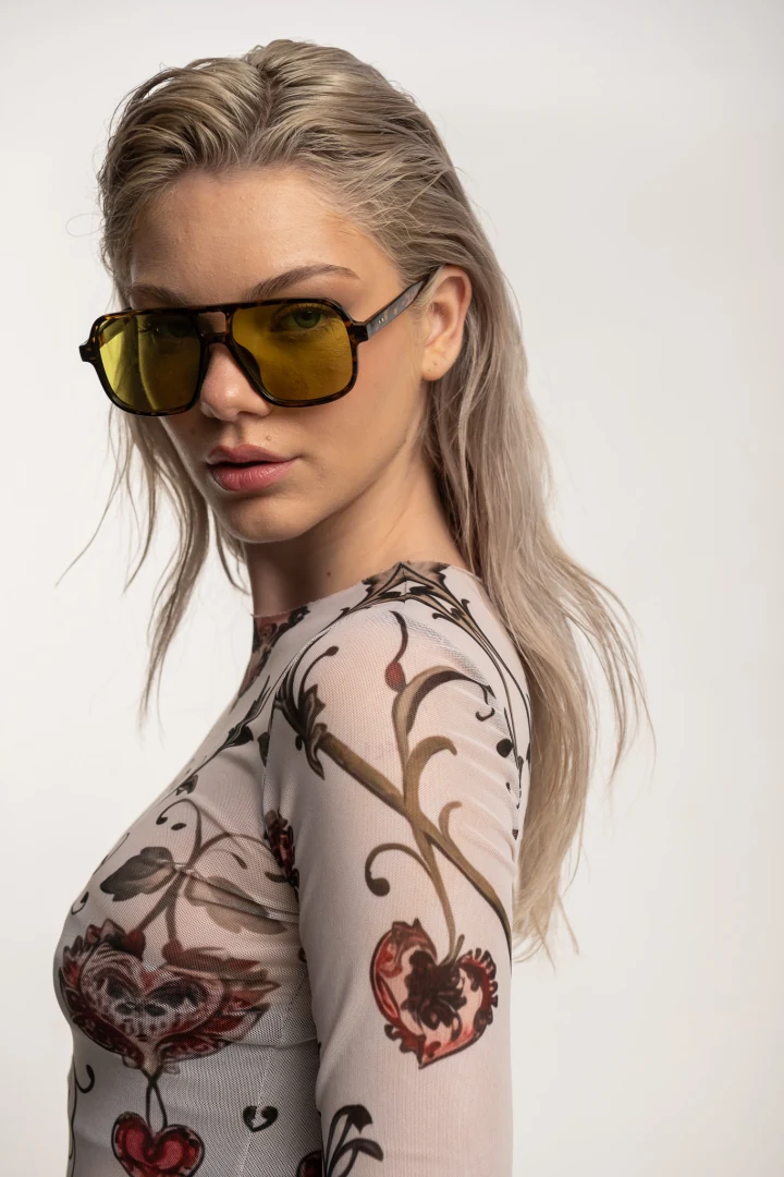 γυναικείο patterned mesh top typelove floral heart aeris σε πόζα 3/4 προφίλ, με κίτρινα γυαλιά ηλίου