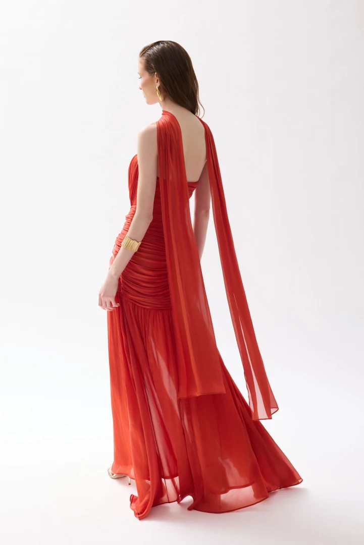 πίσω όψη με το αέρινο βραδινό φόρεμα daphne cecelia burnt orange που αναδεικνύει την κίνηση του υφάσματος