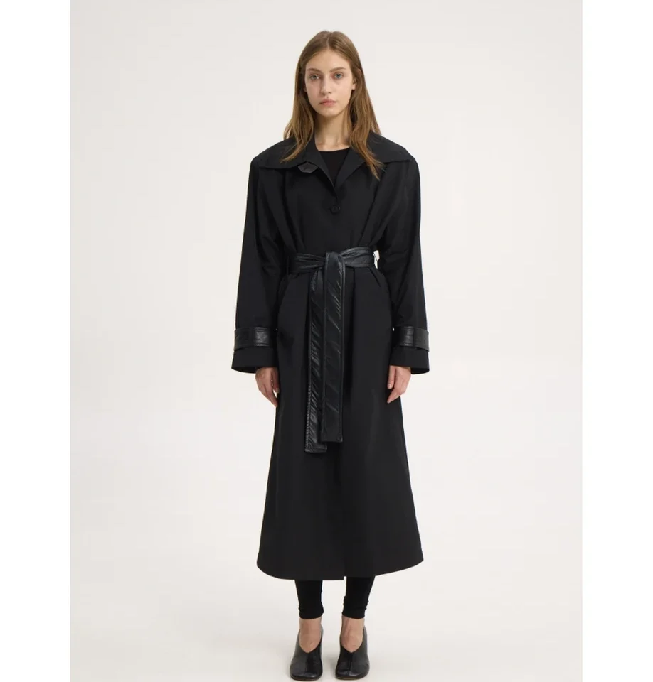 Ολόσωμη λήψη του μοντέλου με την oversized μαύρη καμπαρντίνα Sunsetgo Kendal Trench Coat, αναδεικνύοντας τις βάτες και την κλασική, ίσια γραμμή της