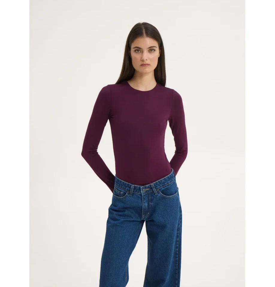 Ολόσωμη μπροστινή λήψη του μοντέλου με το μακρυμάνικο bamboo κορμάκι Sunsetgo Lory Body και τα χέρια πίσω από τη μέση